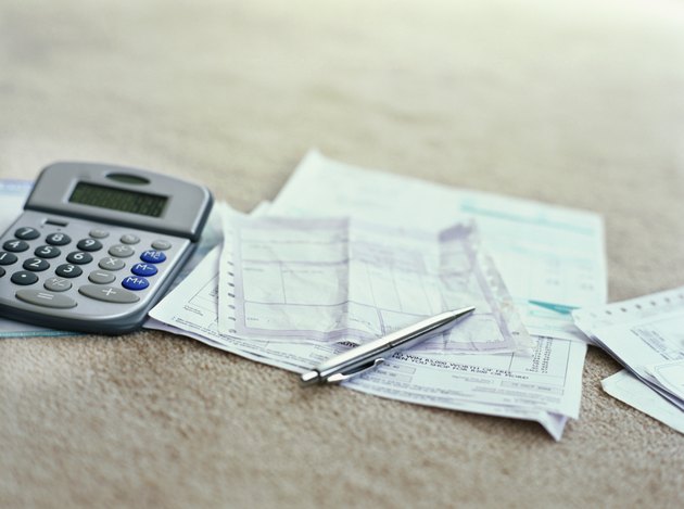 calculator and a ballpoint pen on bills