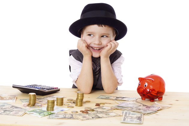 Happy boy at the table with money