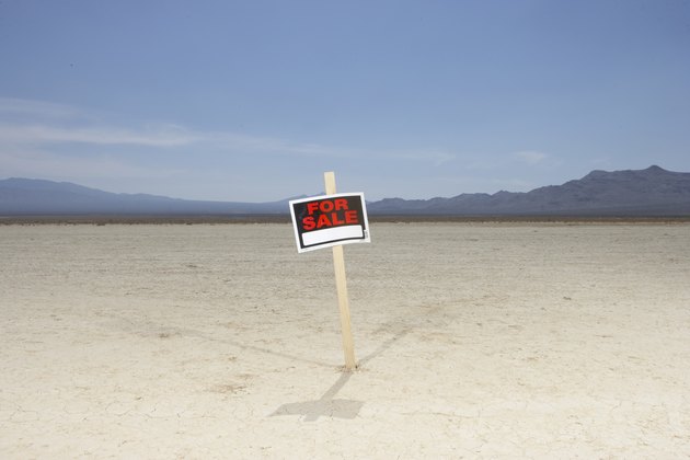 'For sale' sign in dry lake bed