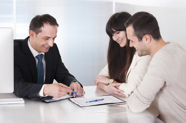 Happy Young Couple Discussing With Consultant