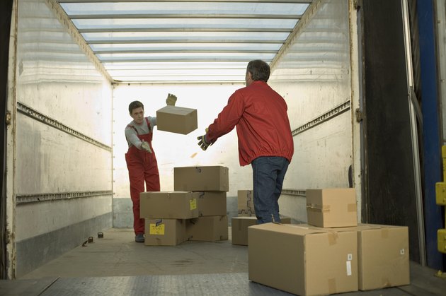 Workers throwing box inside truck