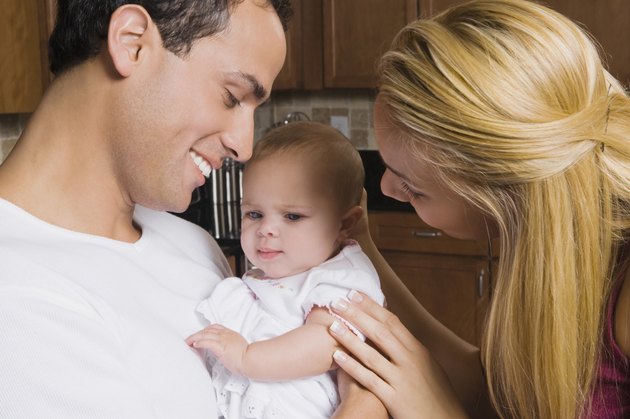 Hispanic parents smiling at baby