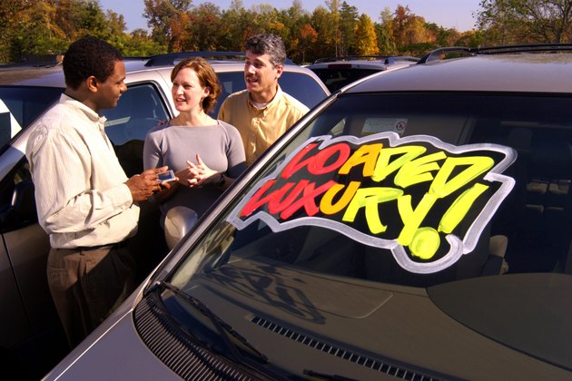 Couple with salesman at car lot
