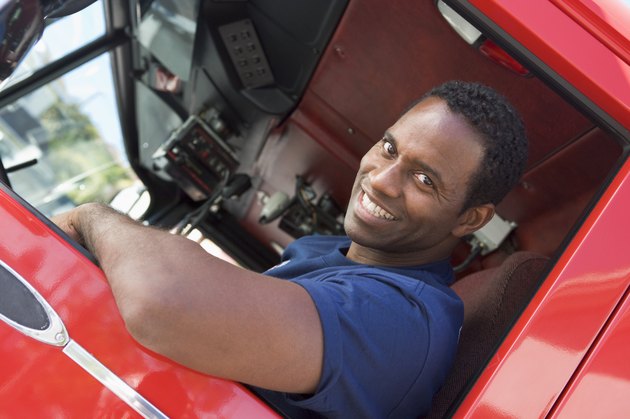 A firefighter sitting in the cab of a fire engine