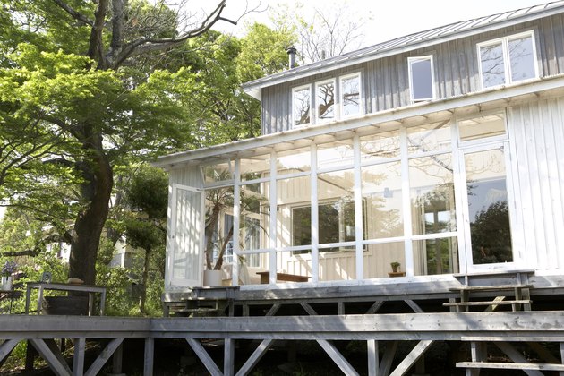 Conservatory of wood-panelled home with wooden deck