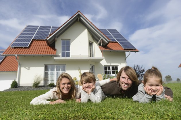 Portrait of family lying on lawn of new home