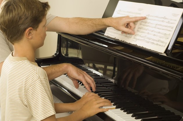 Instructor and boy playing piano