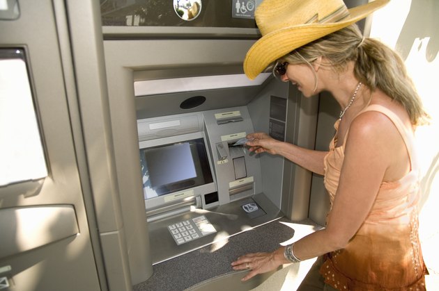 Woman using automatic teller machine