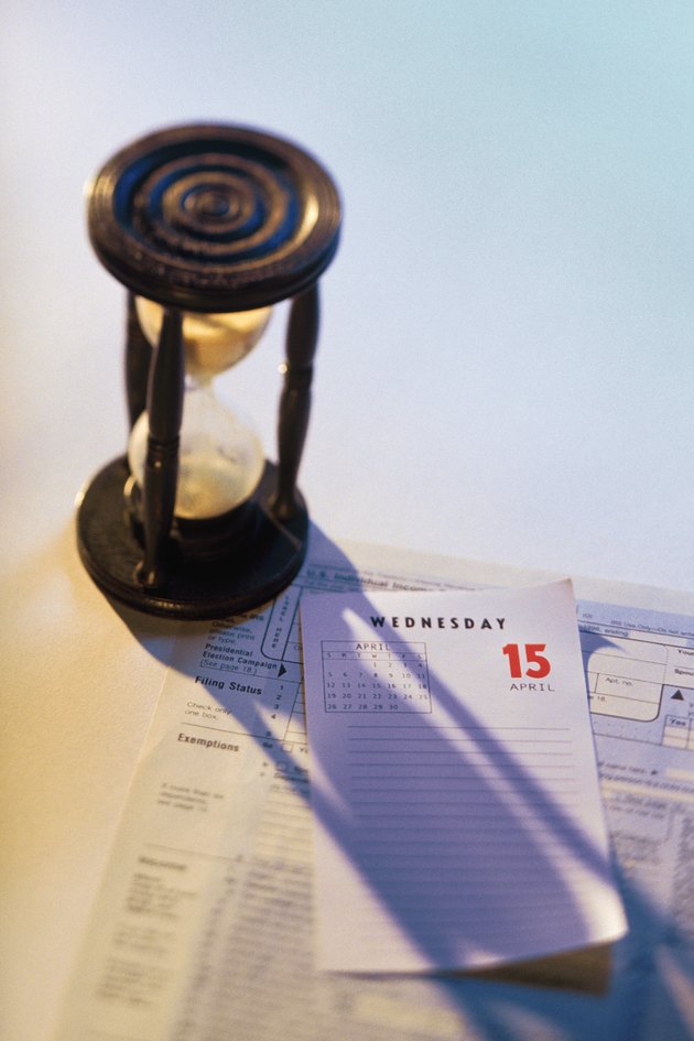 Hourglass on top of calendar page and tax form