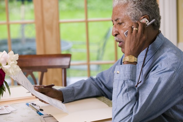 Man talking on phone and reading paperwork