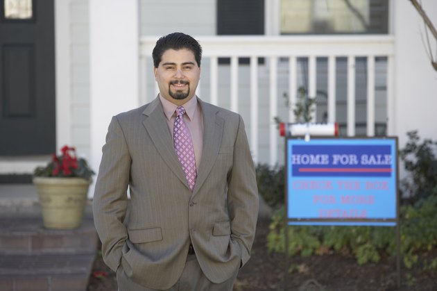 Portrait of a mature man standing in front of a house