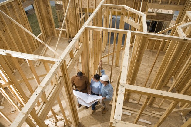 Architects with blueprints at construction site