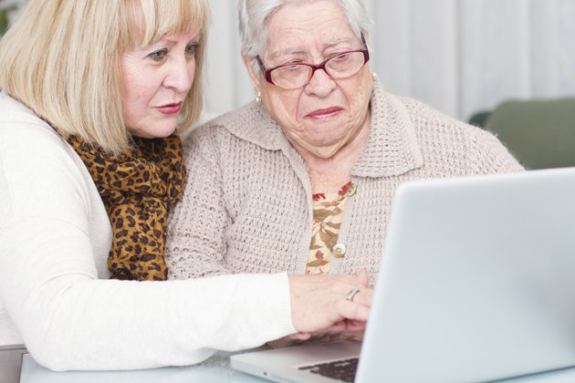 Learning Internet. Daughter teaches her elderly mother using a computer