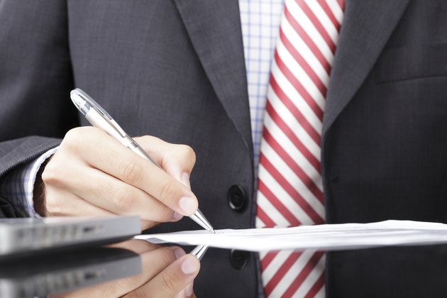 Businessman writing on a form