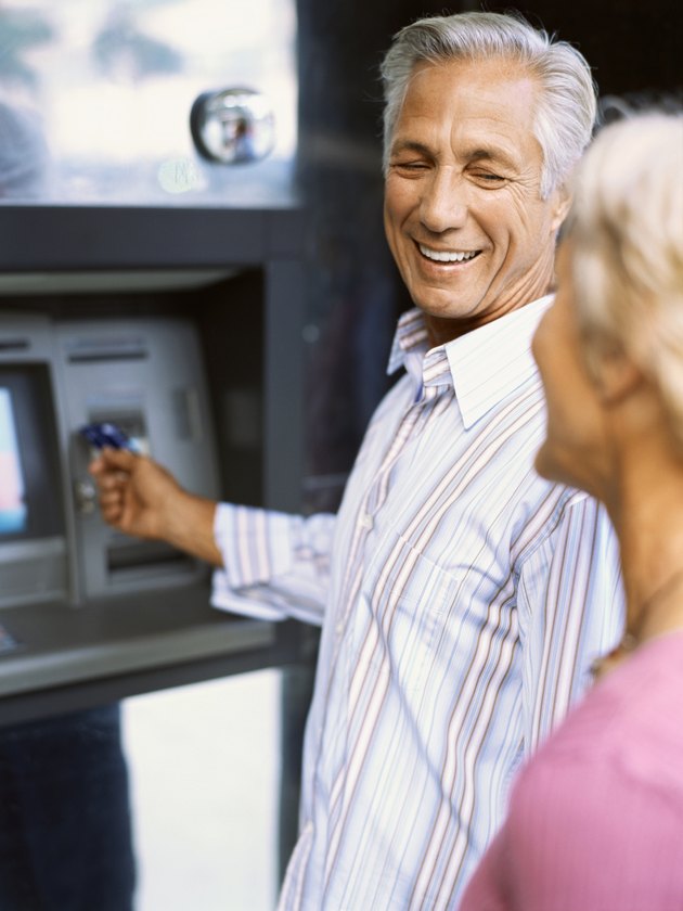 Side view of a mature couple at an ATM