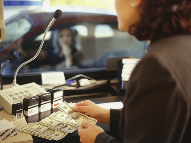 Teller counting money in drive threw bank window