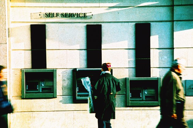 a person standing at an automatic transaction machine