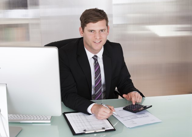 Happy young man calculating finances