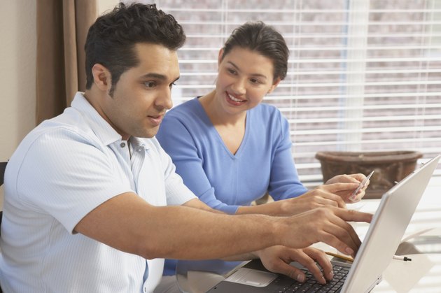 Side profile of a young couple in front of a laptop