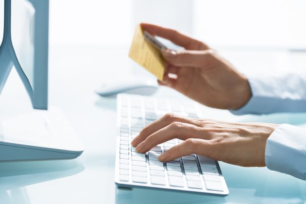 Woman shopping using computer and credit card.indoor.close-up