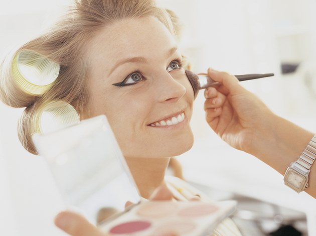 Make up Artist Applying Blusher to a Smiling Female Model