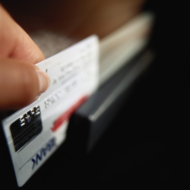 Person swiping credit card, close-up (focus on hand)