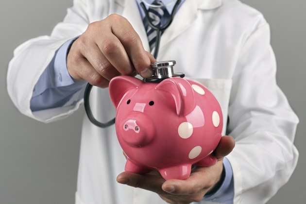 Doctor holding stethoscope to piggy bank