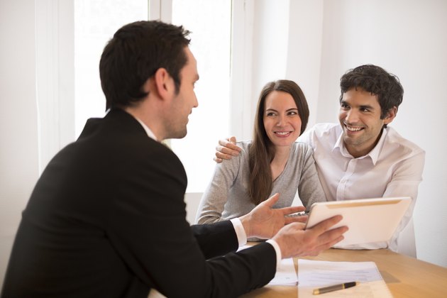 Young Couple meeting real-estate agent to buy property, presentation tablet