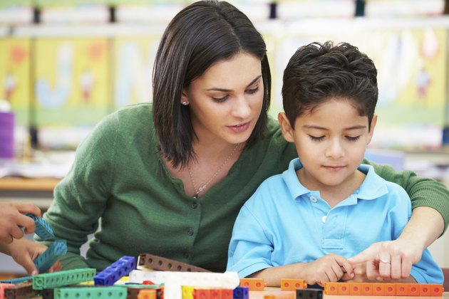 Elementary Pupil Counting With Teacher In Classroom