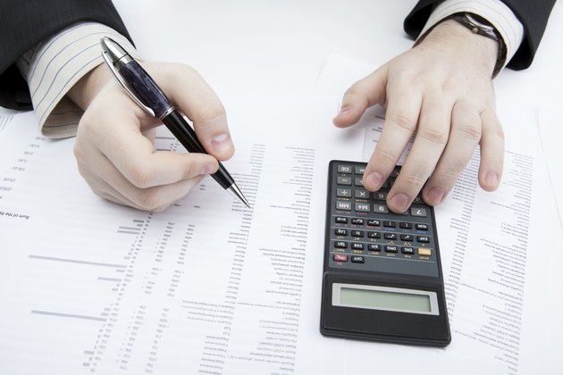 businessman holding a pen and counts the budget
