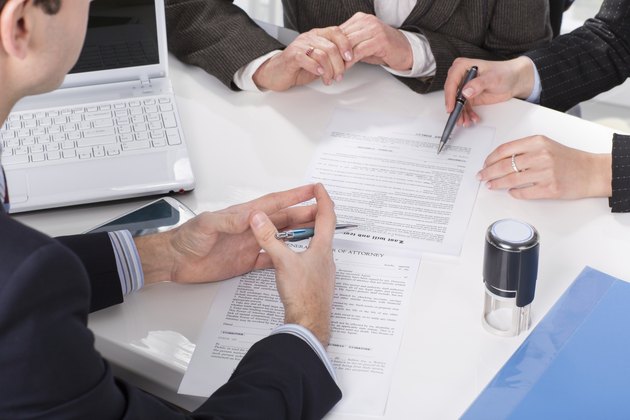hands of three people, signing documents