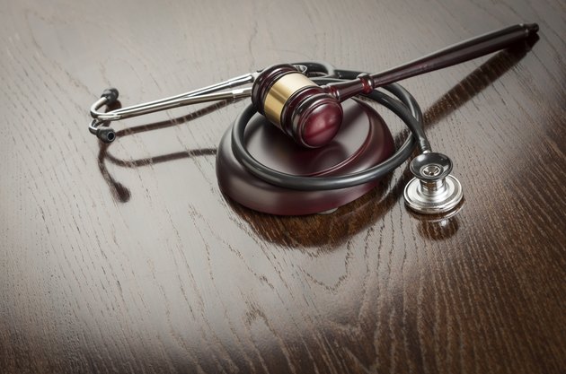 Gavel and Stethoscope on Reflective Table