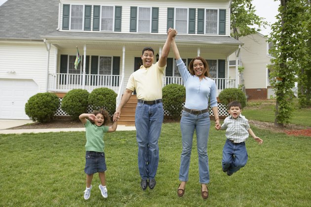 Family jumping together in front yard