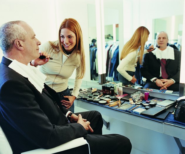 TV Presenter Receiving a Brushing of Foundation From a Makeup Artist in the Dressing Room of a TV Studio