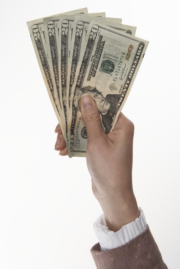 Woman holding US currency (focus on currency)
