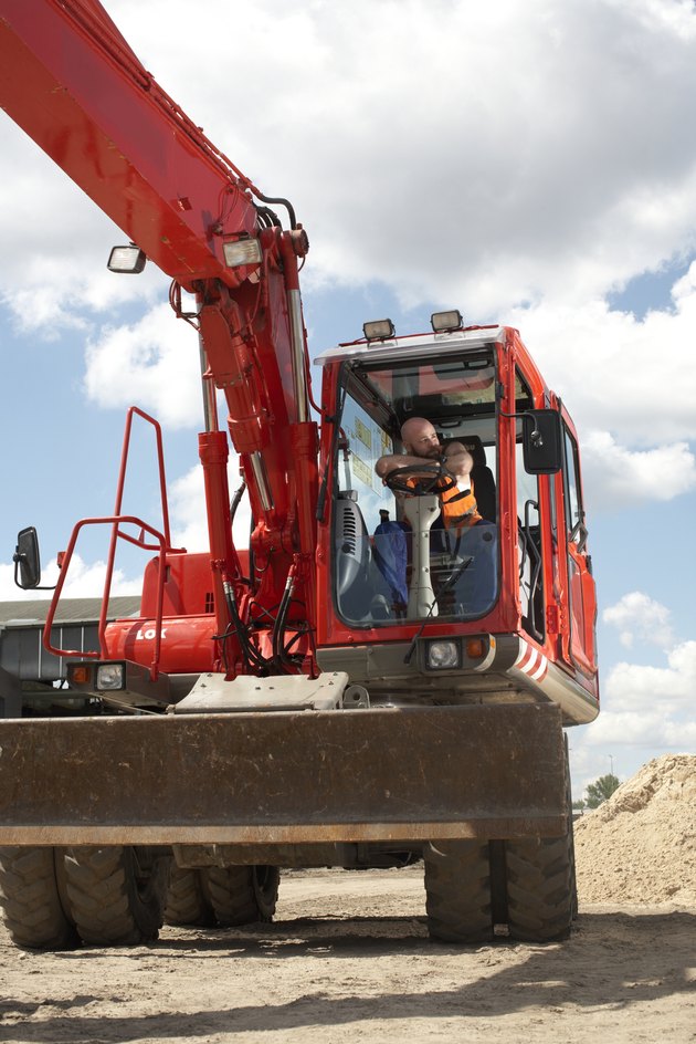 Construction worker sitting in cab of machinery