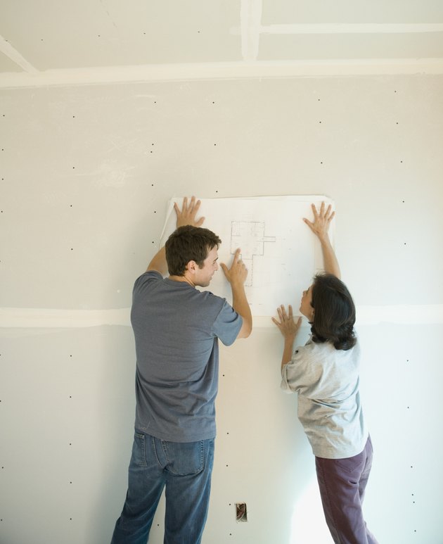 Couple looking at blueprints inside construction site