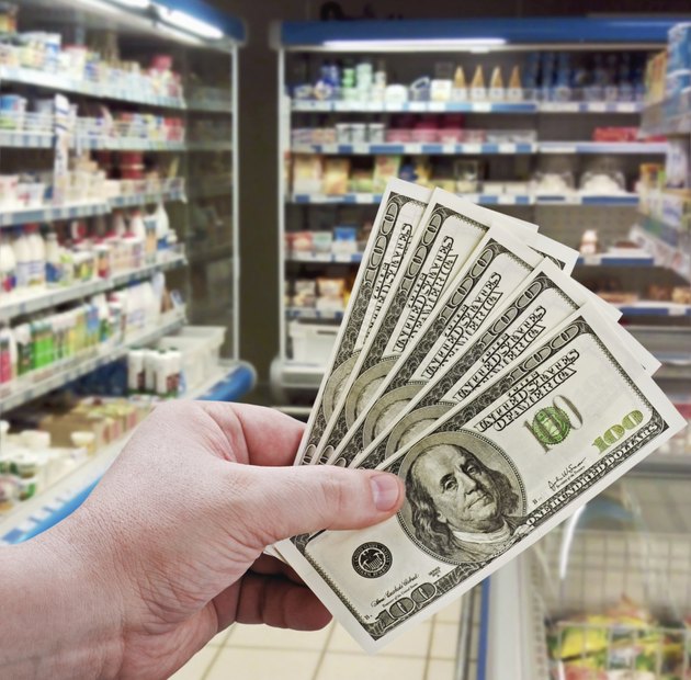 hand holding money on shopping in the supermarket