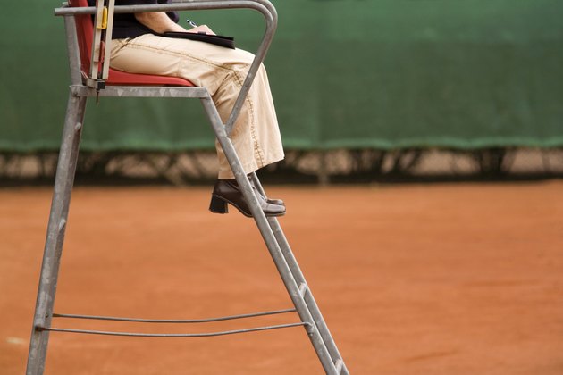 female referee on a clay tennis court