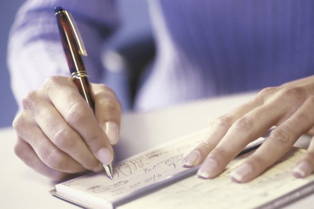 Close-up of a person writing a check