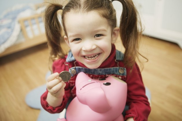 Girl putting coin in piggy bank
