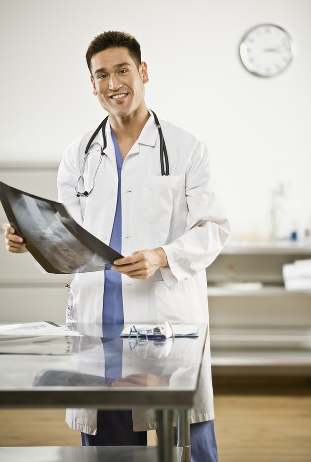 Asian male doctor holding x-ray