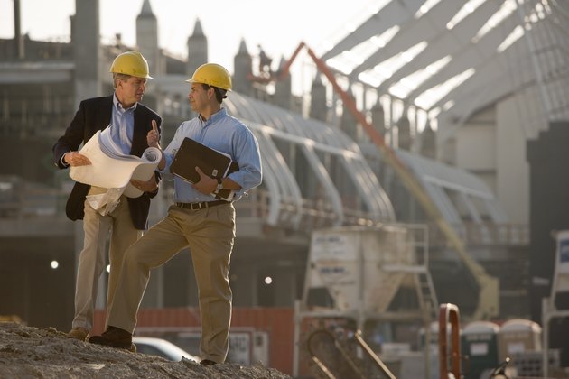 Architects with blueprints at construction site