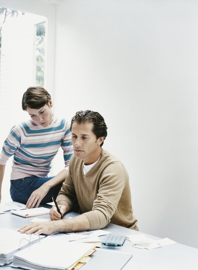 Couple Sat at a Table Calculating Their Personal Finances