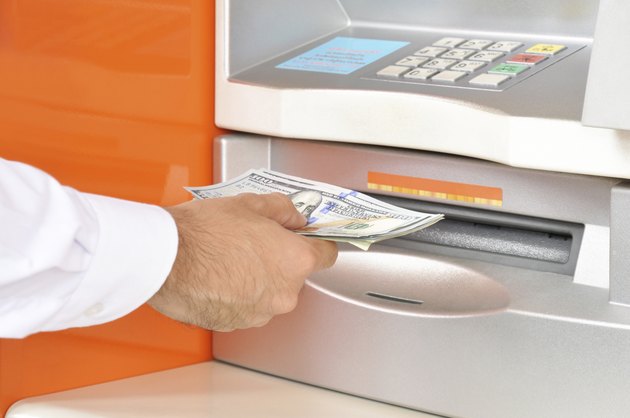 Hand taking money from ATM