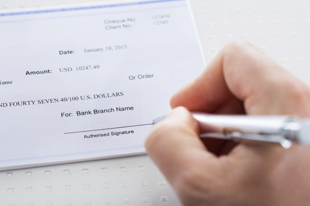 Hand With Pen Over Checkbook