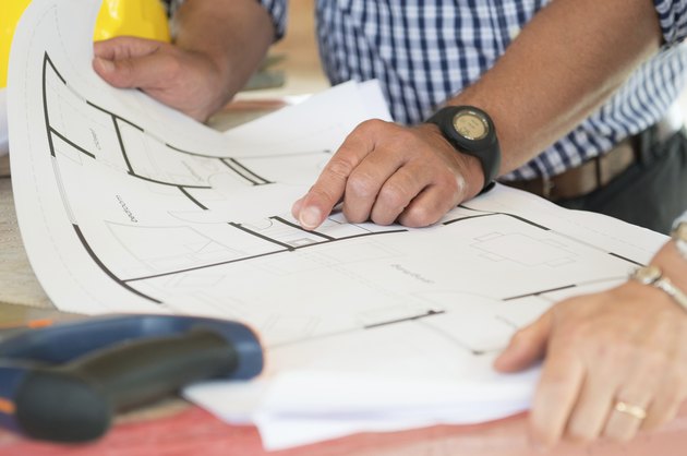 Architect Showing Plan On Blueprint