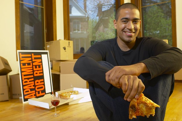 Man eating pizza in new apartment