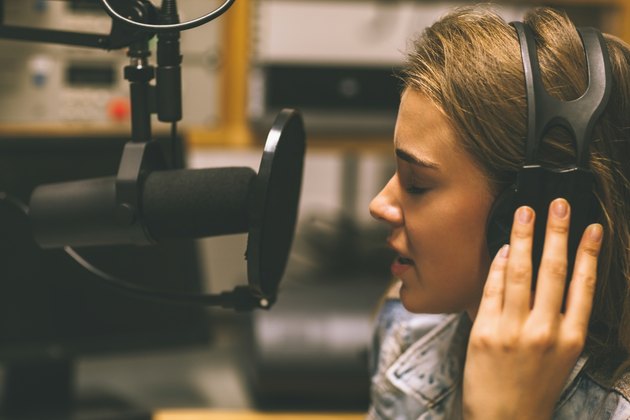 Focused pretty singer recording a song