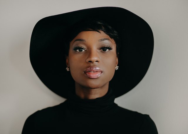 Portrait of beautiful young Black woman wearing wide-brimmed hat